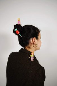 תמונת צד של אישה לבושה צנוע ומקושטת בסיכות צבעוניות- מתוך פוסט בנושא מאתגר אותנו באתר של מאור קפלן- מובילה תהליכי חינוך מיני במרחב הדתי