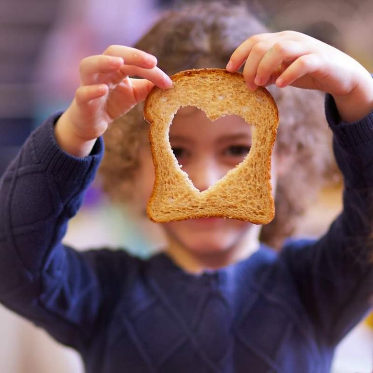 תמונת ילדה מחזיקה פרוסת לחם ובה חור בצורת לב שדרכו רואים את פניה- מתוך פוסט בנושא לא להגזים עם השיח, באתר של מאור קפלן- מובילה תהליכי חינוך מיני במרחב הדתי