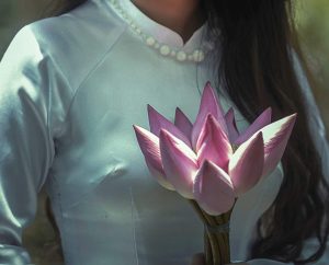 תמונת אישה בשמלה לבנה מחזיקה פרח ורוד ומואר- מתוך פוסט בנושא חשבתי שרק אני, באתר של מאור קפלן- מובילה תהליכי חינוך מיני במרחב הדתי